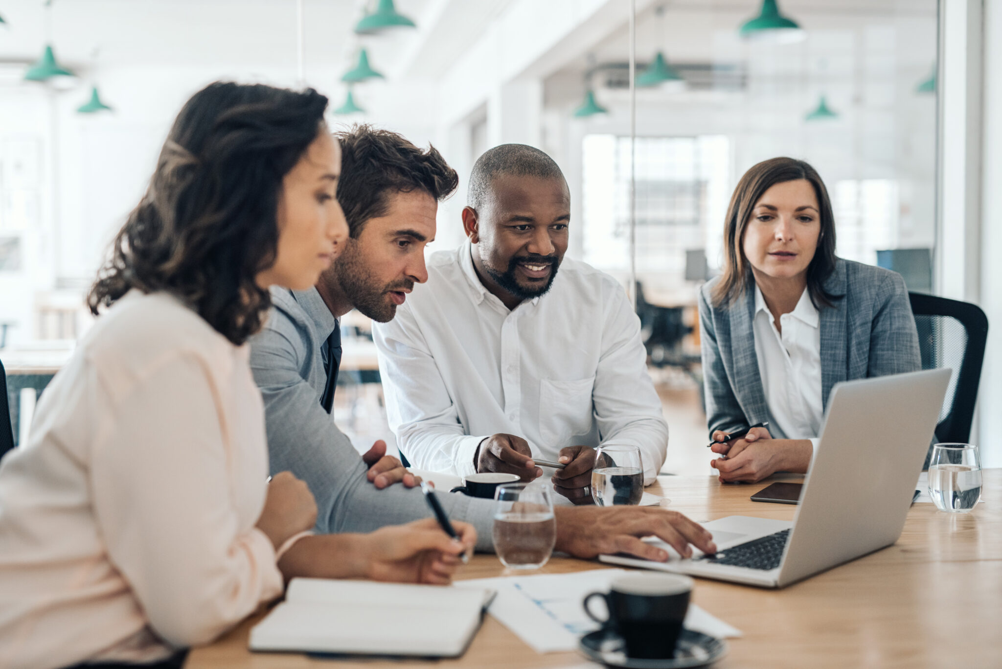 Business professionals collaborating around a laptop